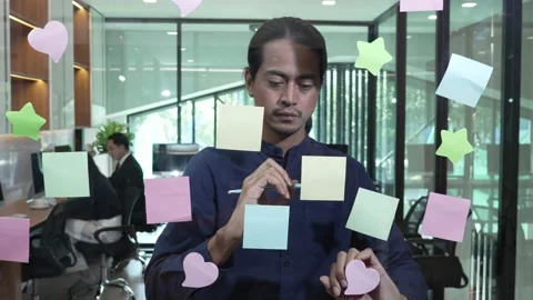 Young man standing in front of many post-it notes on the glass wall Stock Footage 171967023
