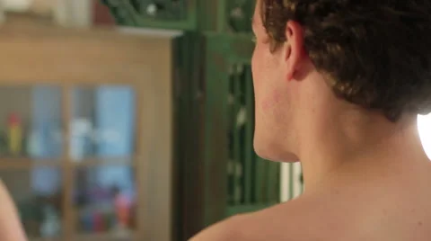 Young man standing in front of the mirror in the morning, brushing his teeth Stock Footage 40843100