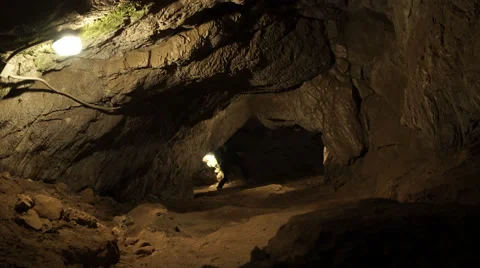 A young man is standing inside a rock cave Stock Footage 63399720