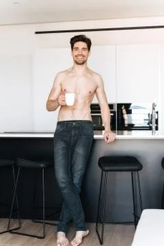 Young man standing at the kitchen Stock Photos
