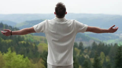 Young Man Standing with Open Arms Overlooking Mountain Landscape Stock Footage 339031197