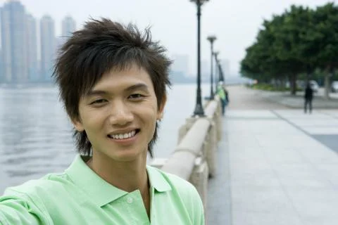 Young man standing by riverside Stock Photos