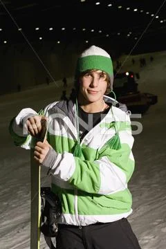 Young man standing on a ski slope with a snowboard Stock Photos