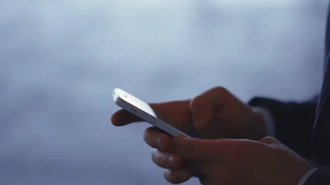 Young man standing with a smartphone in hands on the pier of the metro station Stock Footage 133577277