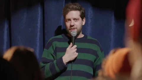Young Man Standing on Stage, Sharing Jokes during Stand Up Performance Stock Footage 333228180