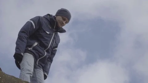 Young man standing on top of a mountain sky background slow motion Video stock 85002390