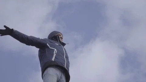 Young man standing on top of a mountain sky background slow motion Stock-Footage 85002470
