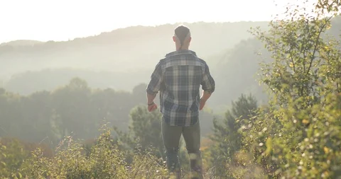 Young man standing on top of mountain, enjoying view of sky with beautiful Stock Footage 126498192