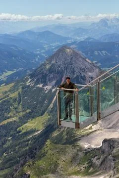 Young man standing at view platform Austrian Dachstein Mountains Stock Photos