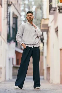 Young man standing while looking at the camera with a proud expression outdoors Stock Photos
