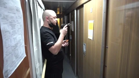 A young man stands in the corridor of a compartment carriage.  drinking tea Stock Footage 143871771