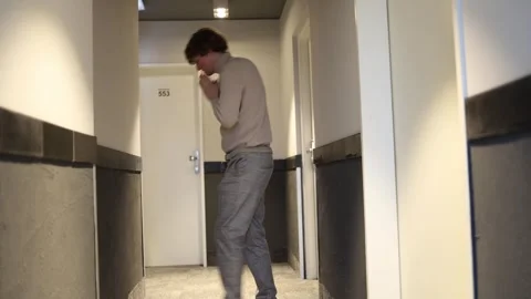 A young man stands in the hallway, deep in anxious thought, with a hopeful look  Stock Footage 291849050