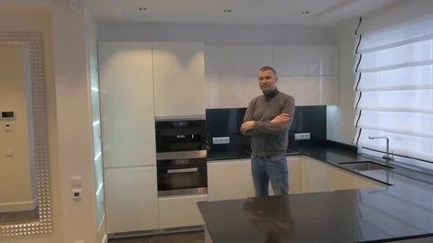 A young man stands in the kitchen and stares into the camera Stock Footage 88255840