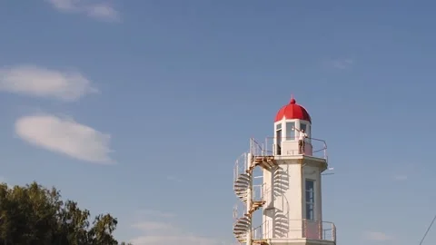 A young man stands at the lighthouse and waves at the camera. beautiful scenic 스톡 동영상 146770869