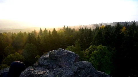 The young man stands on a rock looking at the sunrise in the countryside. Stock Footage 80796966