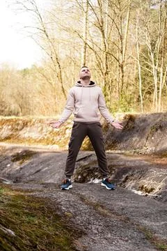 A young man stands on a small mountain in the area of a mountain river Stock Photos