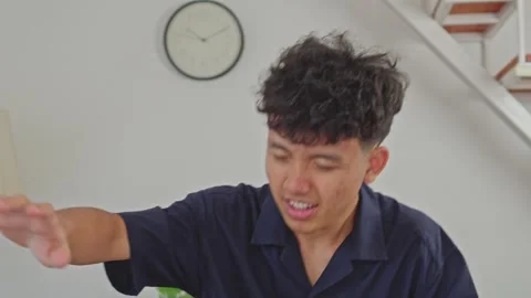 Young man stands up from sofa and instantly struck by painful vertigo attack Stock Footage 335891405