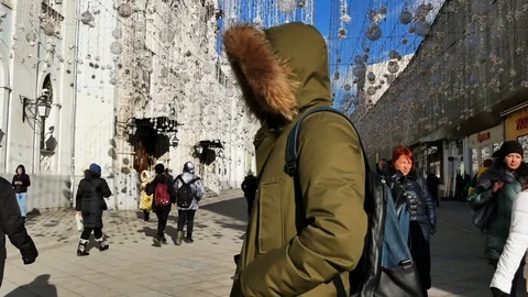 A young man stands on the street in a jacket in the hood. Video stock 103175947