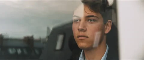 Young man staring outside through the window Stock Footage 203585818
