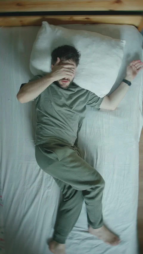 Young Man Startled Awake From Sleep, Jolting In Bed At Home ,vertical video Stock Footage 344458418