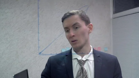 Young man sticking sticky notes near the graphic in office Stock Footage 71929376