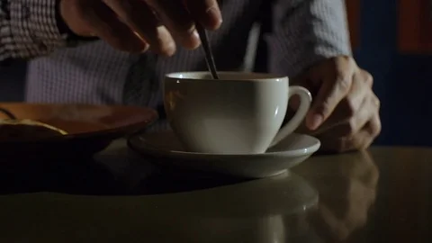 Young man stirring tea with spoon Stock Footage