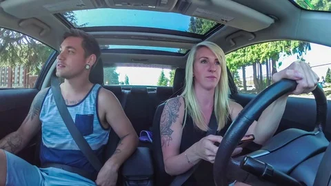 Young man stops girlfriend from texting and driving Stock Footage 92361638