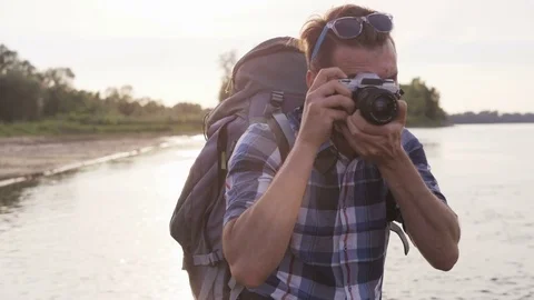 Young Man Stops Taking Pictures and Puts Dark Glasses On Stock Footage 76493543