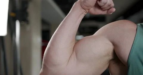 A young man strains his biceps by bending his arm. Stock Footage 158913249