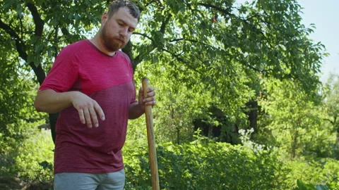 A young man in a straw hat is standing in the middle of his beautiful green Stock Footage 238479467