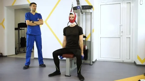 Young man stretching of the spine on exercise equipment with trainer at gym. HD Stock Footage 73134317