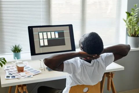 Young Man Stretching at Workplace Back View Stock Photos