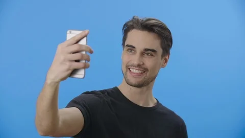 Young man strikes different selfie poses Stock Footage 88399691