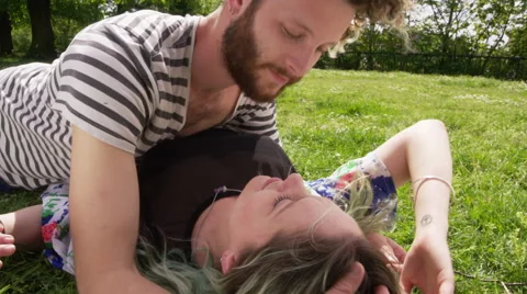 Young man stroking young woman's hair in a city park Stock Footage 58581596