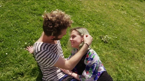 Young man stroking young woman's hair in a city park Stock Footage 58581704