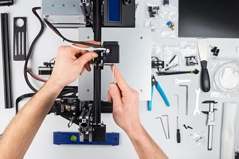 Young man student assembly of 3D printer building kit Stock Photos