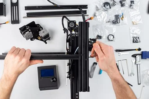 Young man student assembly of 3D printer building kit Fotos de archivo