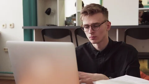 Young man student in glasses using laptop in classroom Stock Footage 85909610