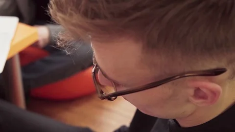 Young man student in glasses writes in a notebook Stock Footage 85909152