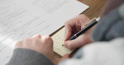 Young man, student learning algebra, chemistry, writing mathematical symbols Stock Footage 124104501