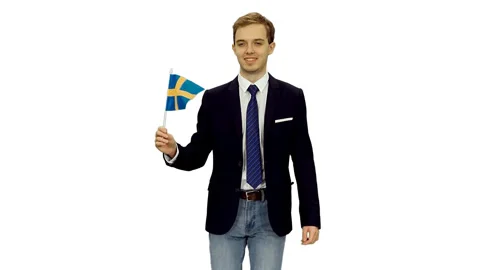 Young man student in suit jacket walks with waving flag of Sweden, alpha Stock Footage 123633331