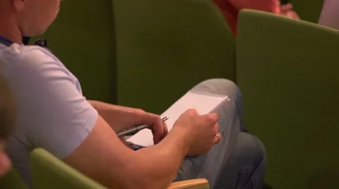 Young man student takes notes during educational or business lecture Stock Footage 40492431