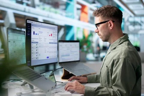 Young Man Studies SaaS Billing Data On Laptop For Finance Tracking. Stock Photos