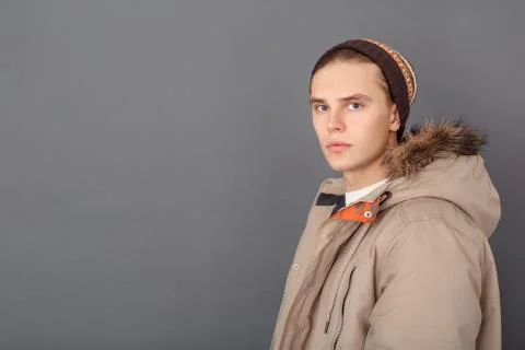 Young man studio isolated on grey winter style looking camera serious Foto stock