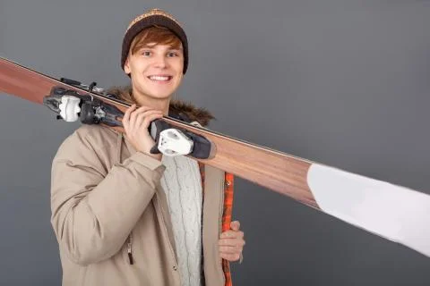 Young man studio isolated on grey winter style carry skis close-up Foto stock