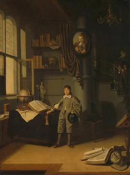 Young man in a study. Boy standing in front of a work table in an interior... Stock Photos