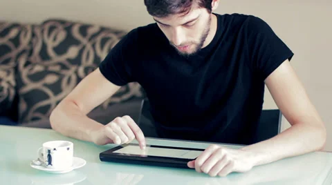 Young man studying on desk with tablet and coffee Stockbeeldmateriaal 32354873