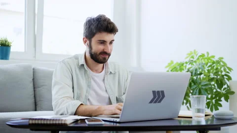 Young man studying at home typing on laptop and doing notes Stock Footage 142532905