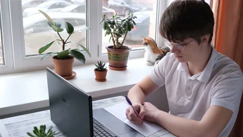 Young man studying at home using laptop. Home school, online education Stock Footage 136506479
