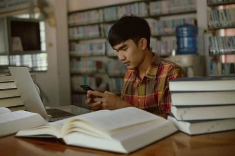 The young man is studying for knowledge in the library Stock Photos